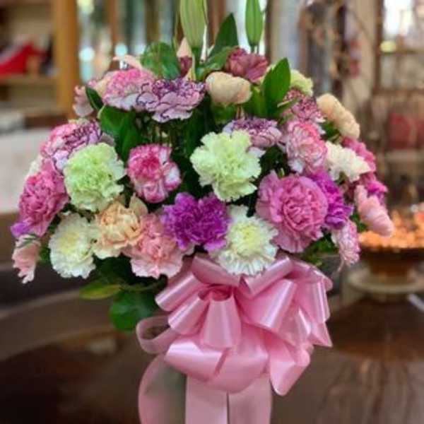 Bouquet of pink and pastel carnations with a pink ribbon bow