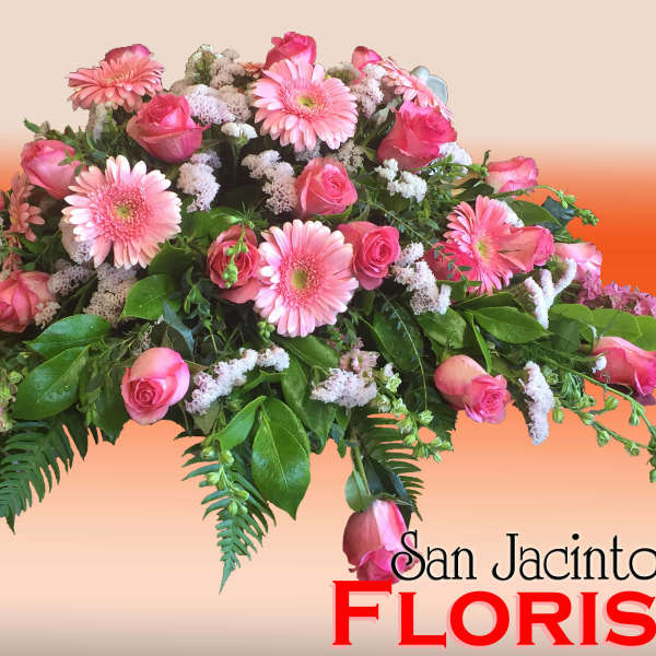 Pink roses and gerbera daisies in a low floral arrangement
