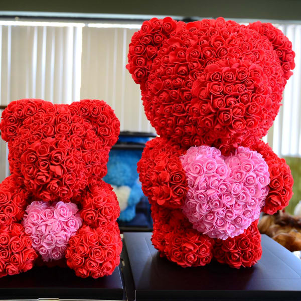Two teddy bears made of red and pink roses on black bases