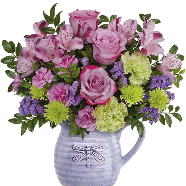 Pink roses and mixed blooms in a lavender pitcher vase