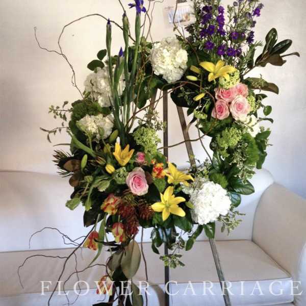 Tall floral standing arrangement with pink roses, yellow lilies, and white hydrangeas