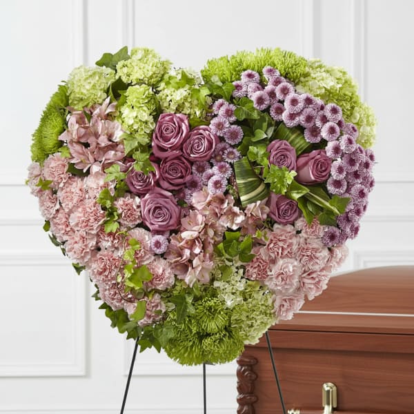 Heart-shaped floral spray with pink and purple flowers on a stand