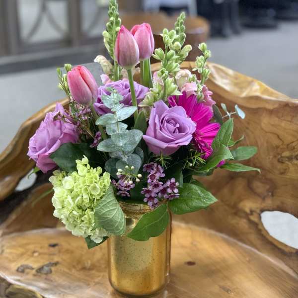 Pink tulips and lavender roses in a gold vase