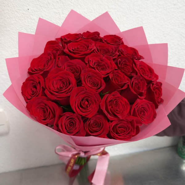 Bouquet of red roses wrapped in pink paper
