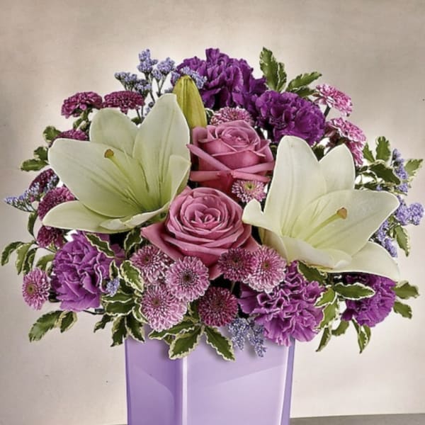 Purple and white floral arrangement in a lavender vase
