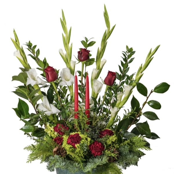 Tall floral arrangement with red roses, white blooms, and red candles