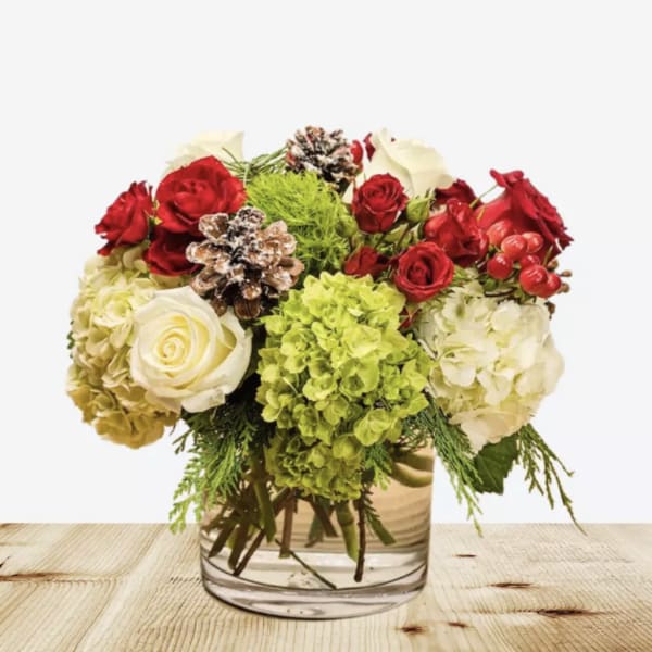 Red and white roses with green hydrangeas in a glass vase