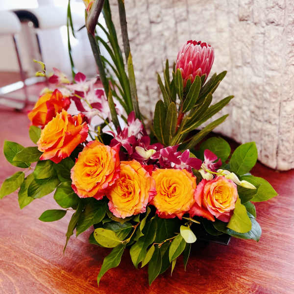 Tropical bouquet with orange roses and bird of paradise flowers
