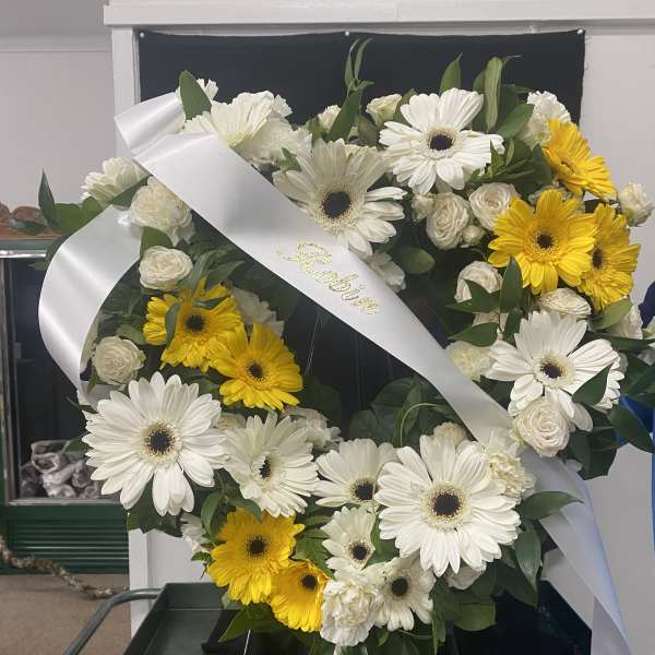 Heart-shaped floral wreath with white and yellow daisies and roses