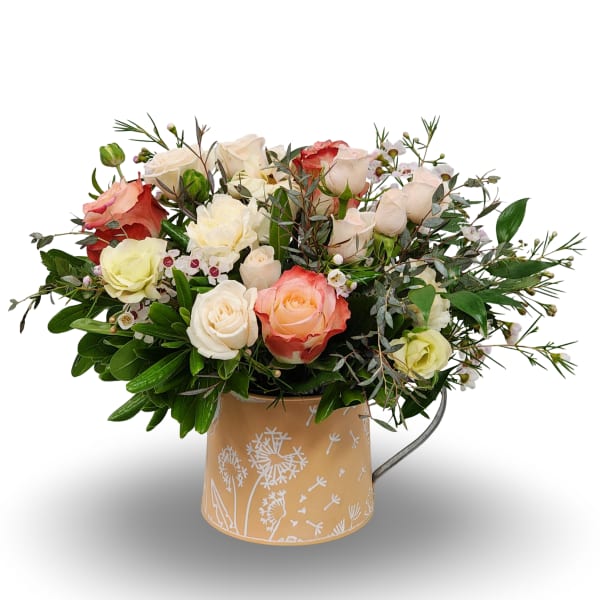 Mixed roses in a tan metal pitcher with white floral print