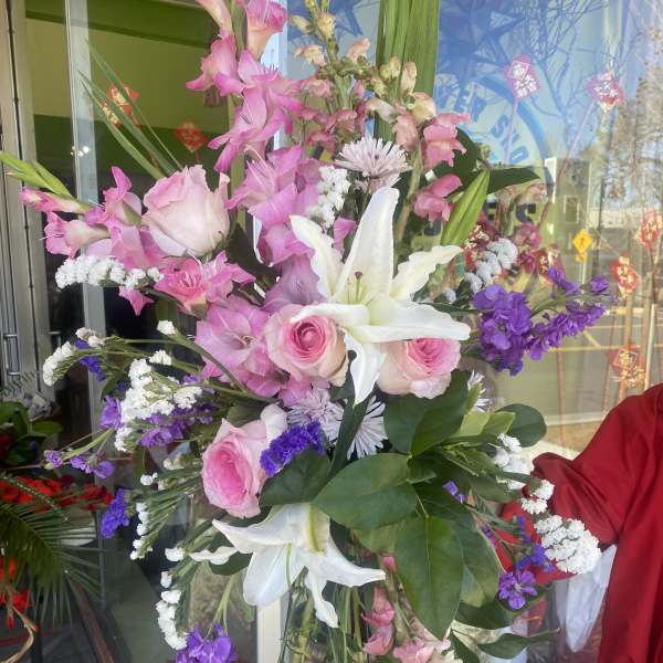 Tall mixed bouquet with pink roses, white lilies, and purple flowers