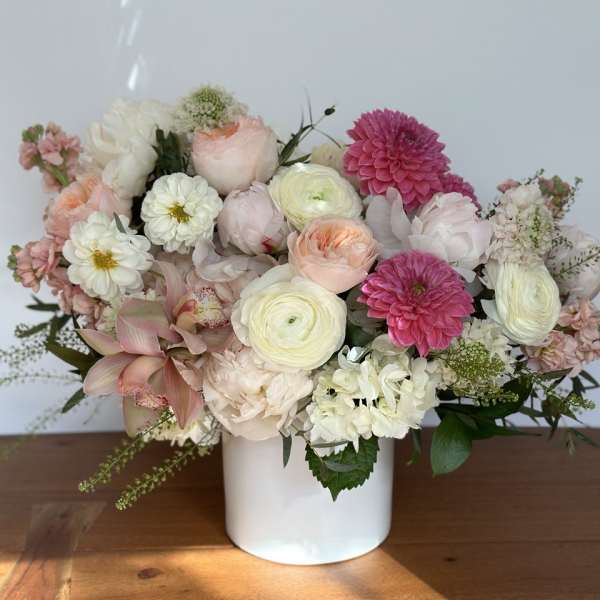 Mixed pastel flower arrangement in a white vase