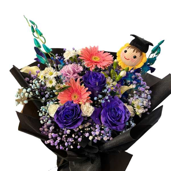 Bouquet of purple roses and pink gerbera daisies with a graduation topper