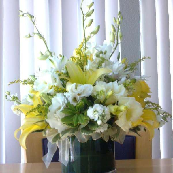 Yellow and white floral arrangement in a glass vase