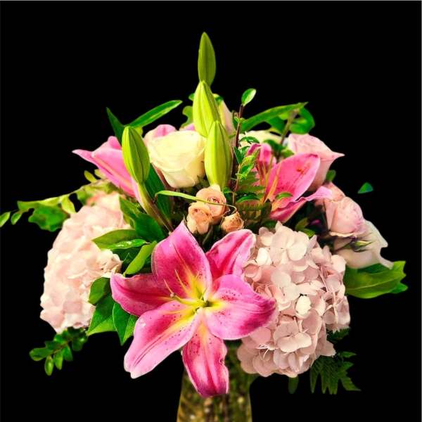 Pink lilies and hydrangeas in a glass vase