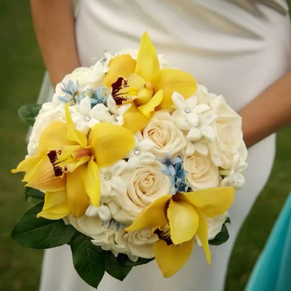 Bridal bouquet with yellow orchids, white roses, and small blue flowers