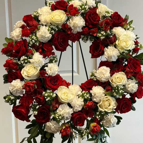 Heart-shaped floral wreath of red and white roses with carnations
