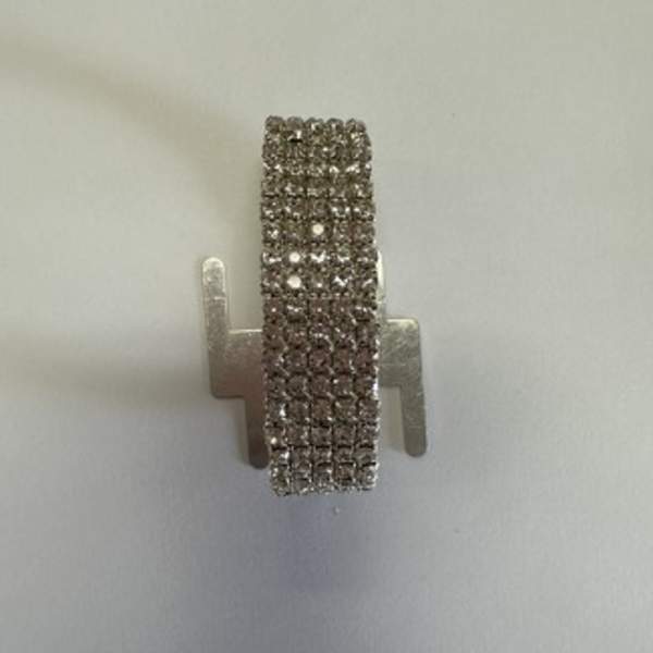 Small silver rhinestone earring on a plain background