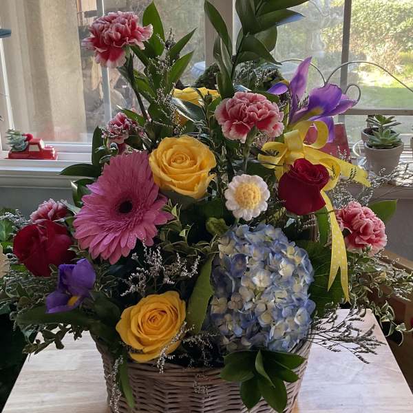 Mixed flower basket with roses, gerbera daisies, hydrangea, and carnations