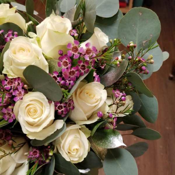Bouquet of white roses with purple filler flowers and eucalyptus