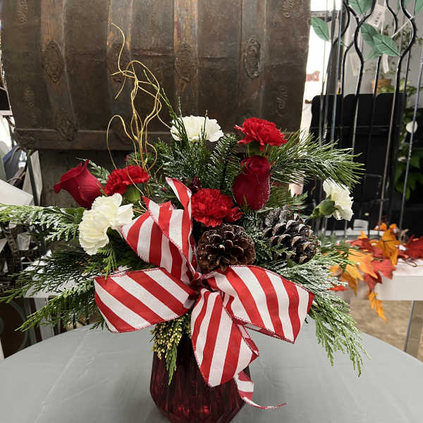 Holiday bouquet with red and white carnations in a red vase