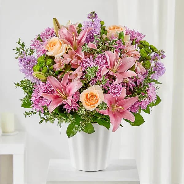 Pink lilies and peach roses in a white vase