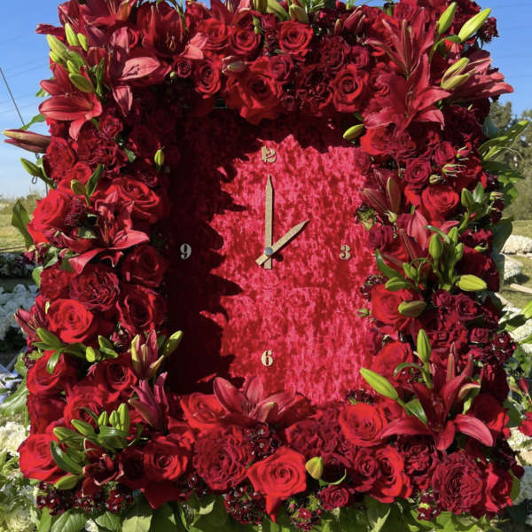 Large red floral clock covered in roses and lilies