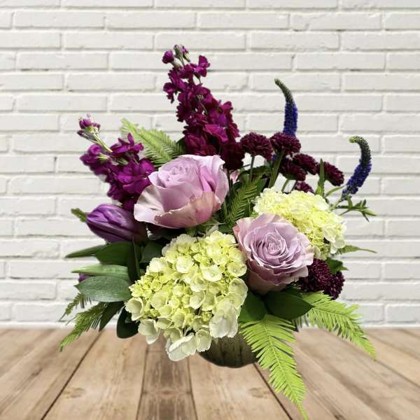 Mixed bouquet with lavender roses, hydrangeas, and purple blooms in a vase