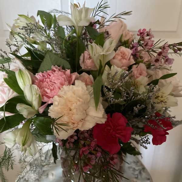 Mixed bouquet of pink, white, and red flowers in a glass vase
