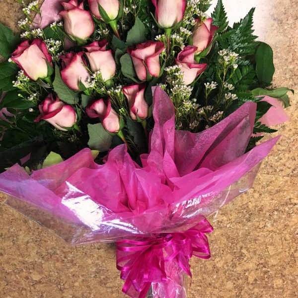 Bouquet of pink roses wrapped in bright pink paper
