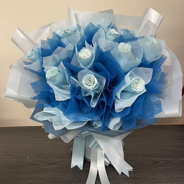 Blue and white rose bouquet wrapped in layered paper