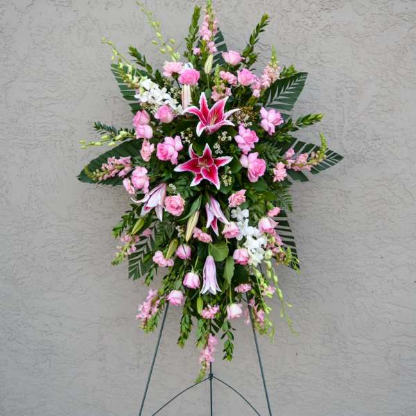 Standing floral spray with pink lilies and roses on an easel