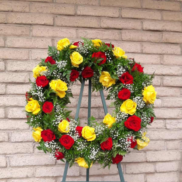 Circular wreath of red and yellow roses on a stand