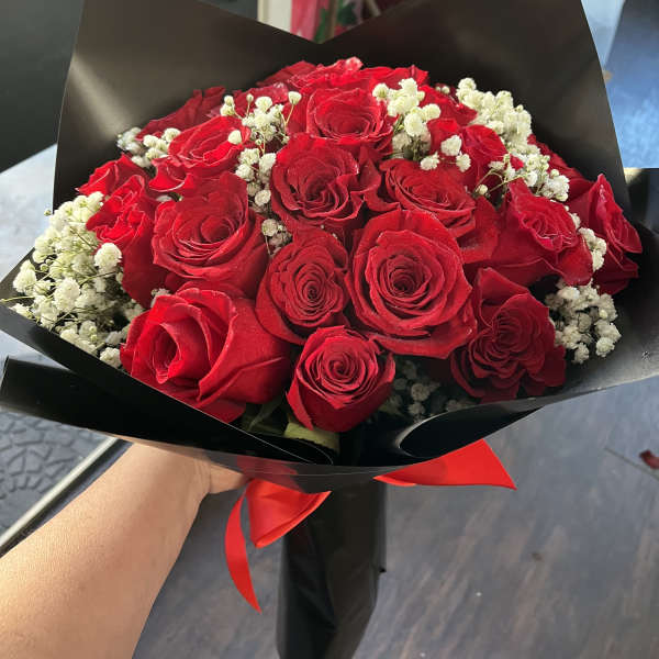 Bouquet of red roses with white baby's breath in black wrap