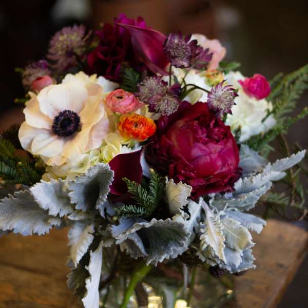 Mixed bouquet in a clear glass vase with pink, white, and burgundy blooms