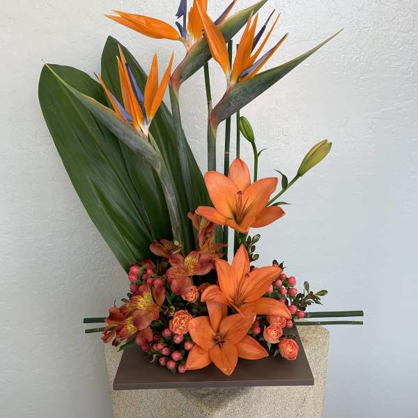 Tall tropical arrangement with orange birds of paradise and lilies