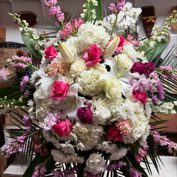 Large bouquet of white lilies, pink roses, and white hydrangeas with purple accents