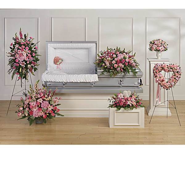Pink floral funeral casket spray with matching standing arrangements