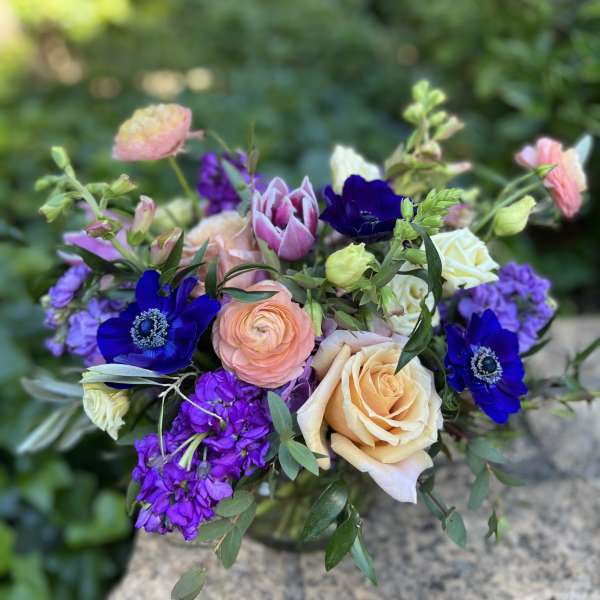 Bouquet of peach roses, purple blooms, and pink tulips