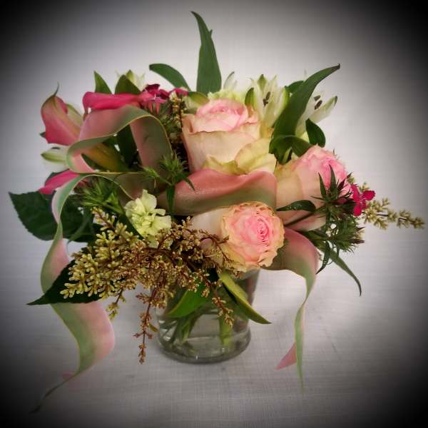 Pink and cream bouquet in a clear glass vase