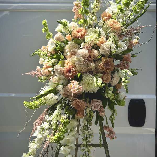 Large peach and white floral spray on an easel