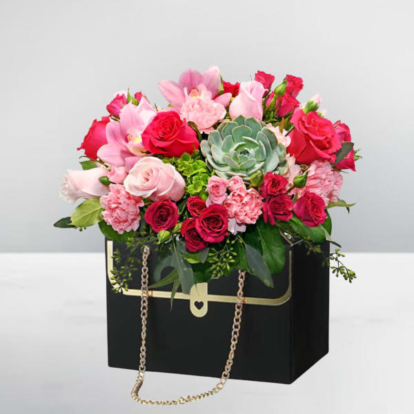 Pink and red rose bouquet in a black box with a gold chain handle