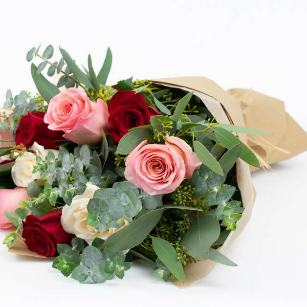 Bouquet of pink, red, and white roses wrapped in paper