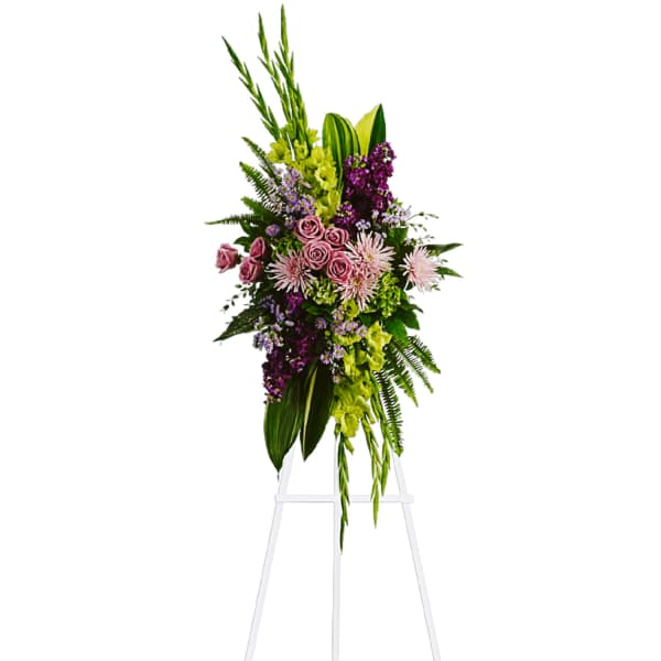 Tall floral spray with pink and purple flowers on a white easel