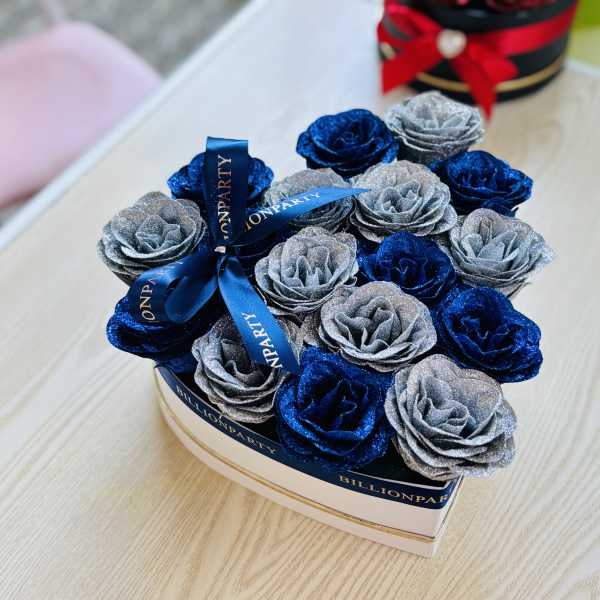 Box of glittery blue and silver roses tied with a ribbon