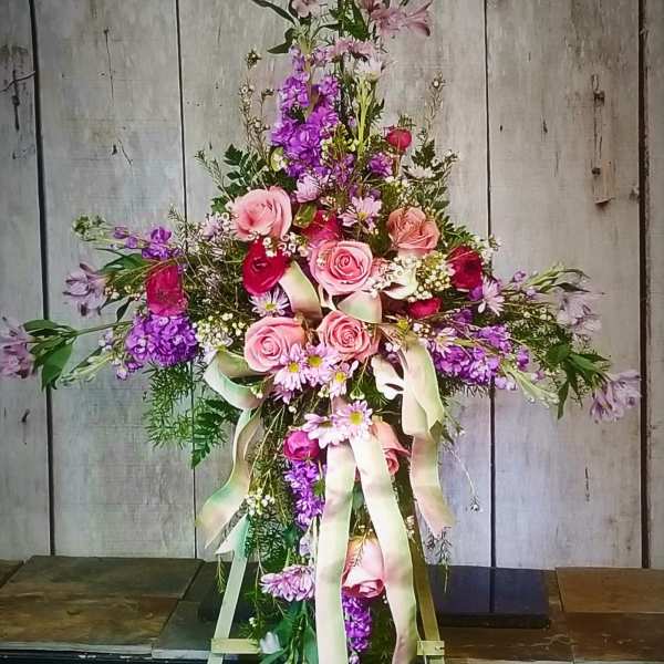 Tall floral spray with pink and purple flowers on a stand