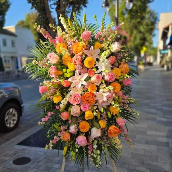 Large standing floral spray with pink, orange, and white blooms