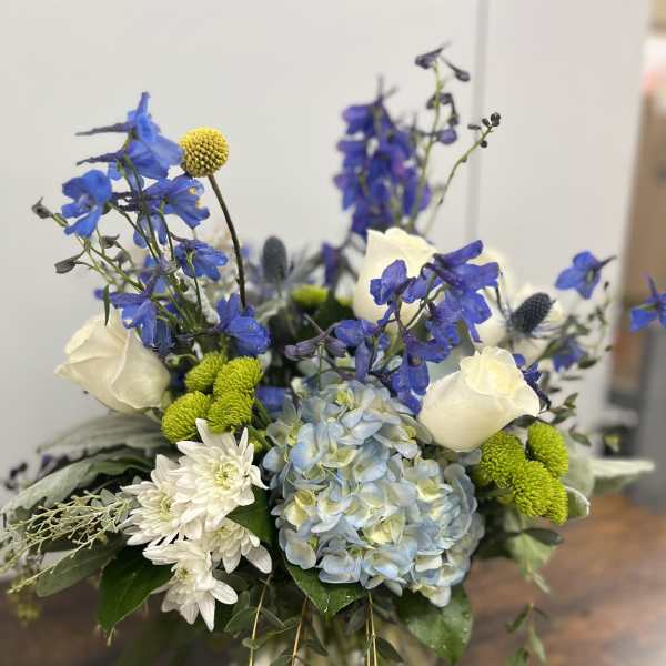 Blue and white floral arrangement in a glass vase