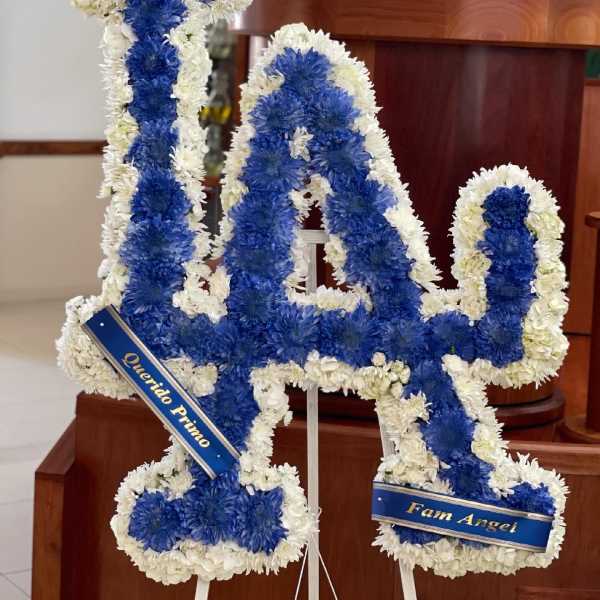 Blue and white floral tribute shaped like the number 14 on a stand