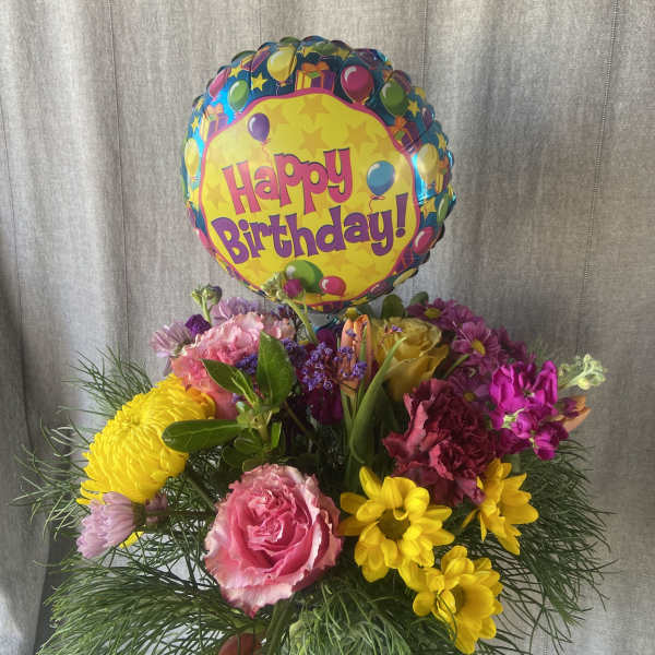 Birthday balloon above a colorful mixed flower bouquet
